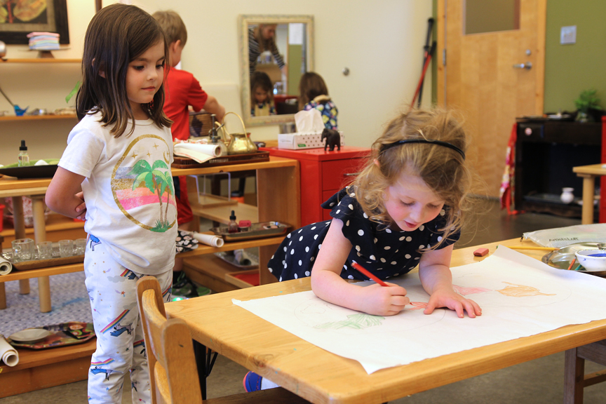 A Primary student observes another child who is working.